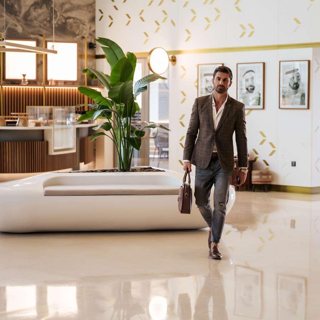 The First Collection Dubai Business Bay酒店 内观 照片 A man walking through a lobby